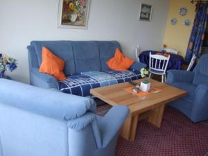 a living room with a blue couch and a wooden table at Appartement Lohf in Glücksburg