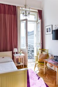 
a room with a bed, chair, table and window at Pension Riedl in Vienna
