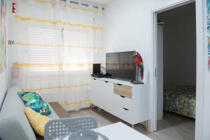 una sala de estar con TV y un loro en una cómoda en Tropical house, en Sesimbra