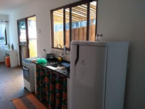 a kitchen with a white refrigerator and a sink at Casa Linda Ilhabela in Ilhabela +12 photos