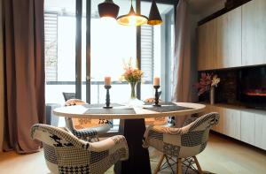 a table and chairs in a room with a fireplace at Brunetti Design Apartment in Prague