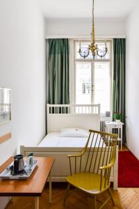 a bedroom with a bed and a table and a chair at Pension Riedl in Vienna