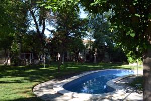 a swimming pool in a yard with trees at Gran Posada La Mesnada in Olmedo