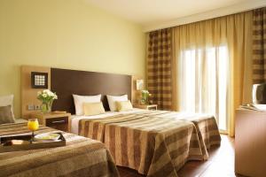 
a hotel room with two beds and a television at Anessis in Thessaloniki
