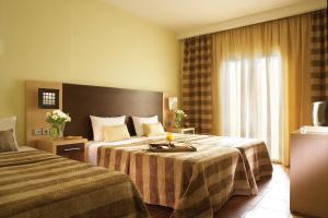 テッサロニキにあるAnessisのベッド2台と窓が備わるホテルルームです。