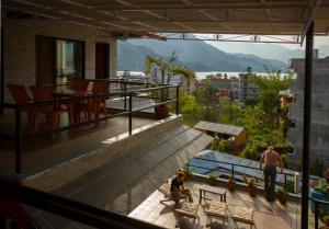 una donna seduta sul balcone di una casa di The North Face Inn a Pokhara