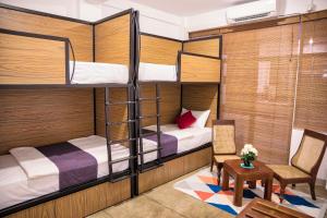 a room with two bunk beds and a table and chairs at C 1 Colombo Fort in Colombo