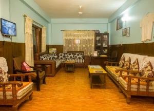 un soggiorno con divani e tavoli in una stanza di The North Face Inn a Pokhara