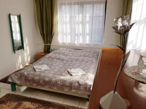 a bedroom with a bed with two towels on it at La Boheme Apartman in Miskolc