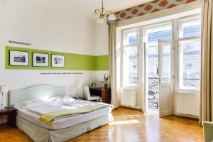 a bedroom with a bed and a desk and windows at Pension Riedl in Vienna