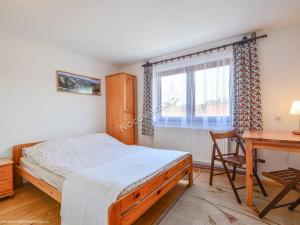 a bedroom with a bed and a desk and a window at Gościniec nad potokiem in Jurgów