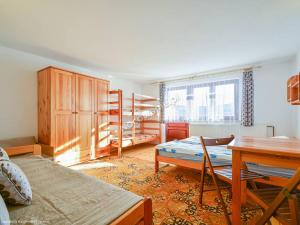 a room with a bed and a desk and a table at Gościniec nad potokiem in Jurgów