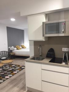 una cocina con fregadero y un sofá en una habitación en Apartamentos Core Suite Sevilla, en Sevilla