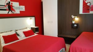 1 dormitorio rojo con 1 cama y pared roja en Thea B&B, en Acquedolci