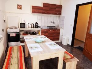 a kitchen with a wooden table in a kitchen at La Boheme Apartman in Miskolc +26 photos