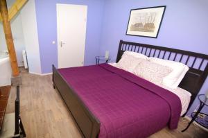 De Violier في Eext: غرفة نوم أرجوانية مع سرير مع لحاف أرجواني