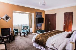 a hotel room with a bed and a tv at Los Leones Hotel Boutique in Arequipa