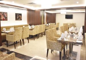 バンガロールにあるSS Lumina Hotelのテーブルと椅子が備わるレストラン