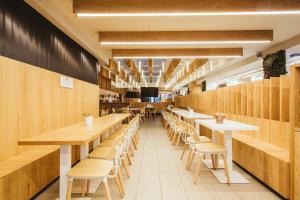 un restaurante con paredes de madera, mesas y sillas en Residencia Universitaria Claudio Coello, en Madrid