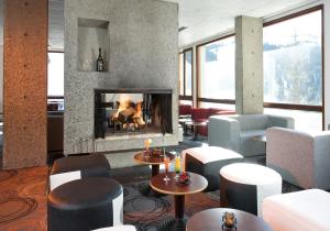 een lobby met een open haard en een aantal stoelen en tafels bij Hôtel Club mmv Le Flaine *** in Flaine