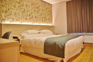 a hotel room with a large bed and a window at Hospedium Hotel La Marina Costa da Morte in Cee