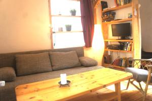 ein Wohnzimmer mit einem Sofa und einem Holztisch in der Unterkunft Ferienhaus Bonn in Bonn