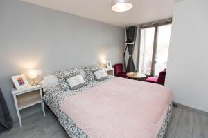 a bedroom with a large bed with a pink blanket at Chambre d'Hôtes des Lys in Montbrison