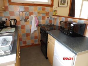 a kitchen with a stove and a counter top at Forest Glen Holiday Park in Invermoriston