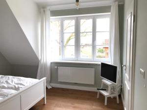 1 dormitorio con cama, radiador y ventana en Ferien Hohes Elbufer en Schnakenbek