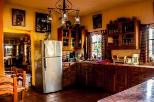 La cuisine est équipée d'un réfrigérateur en acier inoxydable et de placards en bois. dans l'établissement Villa Eggedal, à Santa Cruz La Laguna
