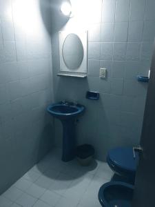 uma casa de banho com um lavatório azul e um WC. em Hotel Condor em Buenos Aires