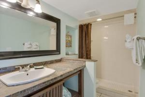un bagno con lavandino, specchio e doccia di Beach Place Guesthouses a Cocoa Beach