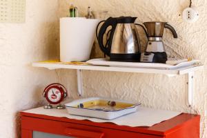 a shelf with a coffee pot on top of a red cabinet at Casa Guia a Marina di Cecina con parcheggio privato in Marina di Cecina