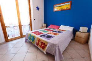 1 dormitorio azul con 1 cama con una manta colorida en Casa Guia, en Marina di Cecina