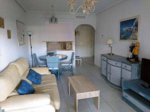 uma sala de estar com um sofá e uma mesa em Apartamento VenAVera Playa Jardines de Nuevo Vera L1-1D Primera Línea WIFI em Vera