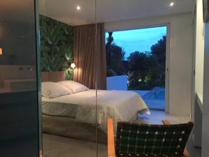 a bedroom with a bed and a large window at Villa Mirano in Èze