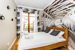 - une chambre avec un grand lit en bois et des draps blancs dans l'établissement Four - Neptun Park by OneApartments, à Gdańsk