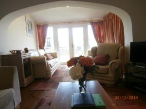 a living room with a vase of flowers on a table at Riverside House in Bideford