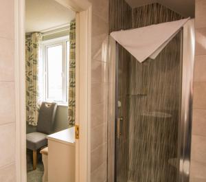 a bathroom with a shower with a glass door at The Pipers Rest in Doolin