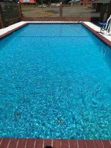 une grande piscine d'eau bleue dans l'établissement Western Motel - Prentiss, à Prentiss