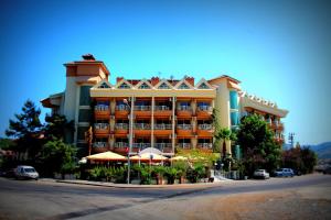 un grand bâtiment avec des parasols en face de celui-ci dans l'établissement Grand Hotel Faros, à Marmaris