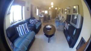 a living room with blue couches and a table at Two-storey Mansion at the Sea in rkadiko Chorio