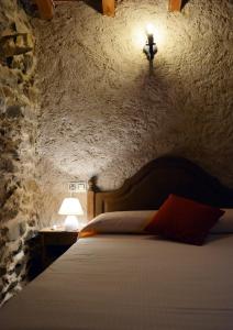 a bedroom with a bed in a stone wall at Casa Rural Xiromo in San Ciprián