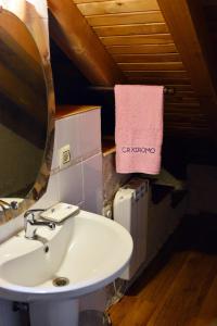 baño con lavabo y toalla rosa en Casa Rural Xiromo, en San Ciprián