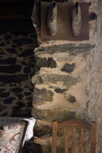 a stone wall with shoes hanging on a wall at Casa Rural Xiromo in San Ciprián