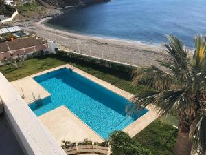 an overhead view of a swimming pool next to a beach at Apartamento Nautilus Beach in Carboneras