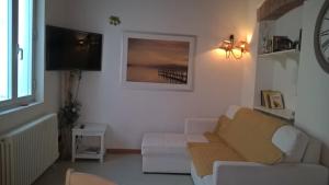 a living room with a white couch and a television at nel cuore di sestri in Sestri Levante