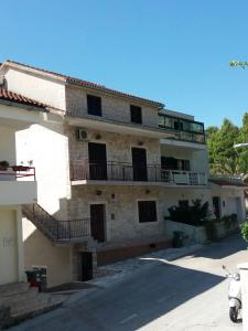 a large brick building with a balcony on the side at Apartmani Kelava in Podgora