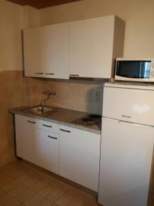 a kitchen with a white refrigerator and a microwave at Apartmani Ivona s pogledom na more in Podgora +19 photos