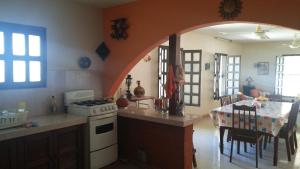 una cucina con piano cottura e una sala da pranzo con tavolo di Casa Trujeque a Sisal